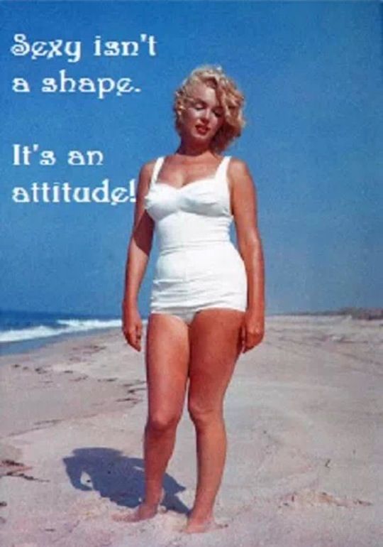 a woman in a white bathing suit standing on the beach