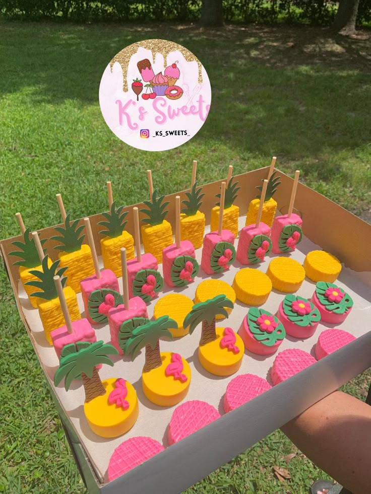 a table topped with cupcakes covered in frosting and pineapple toppings