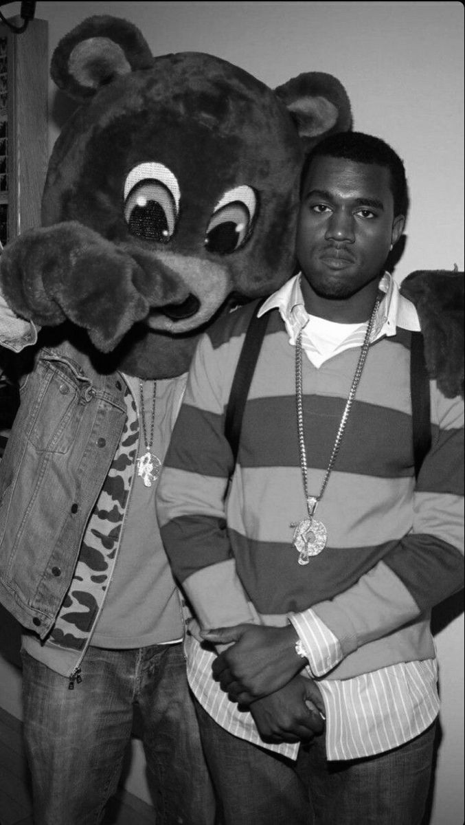 two men standing next to each other near a stuffed animal