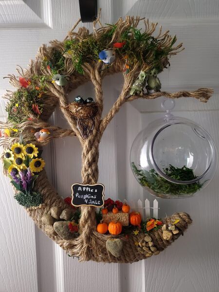 a wreath is hanging on the front door with an image of a tree in it