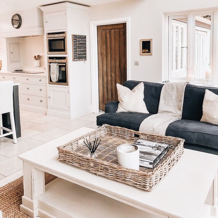 a living room filled with furniture next to a kitchen