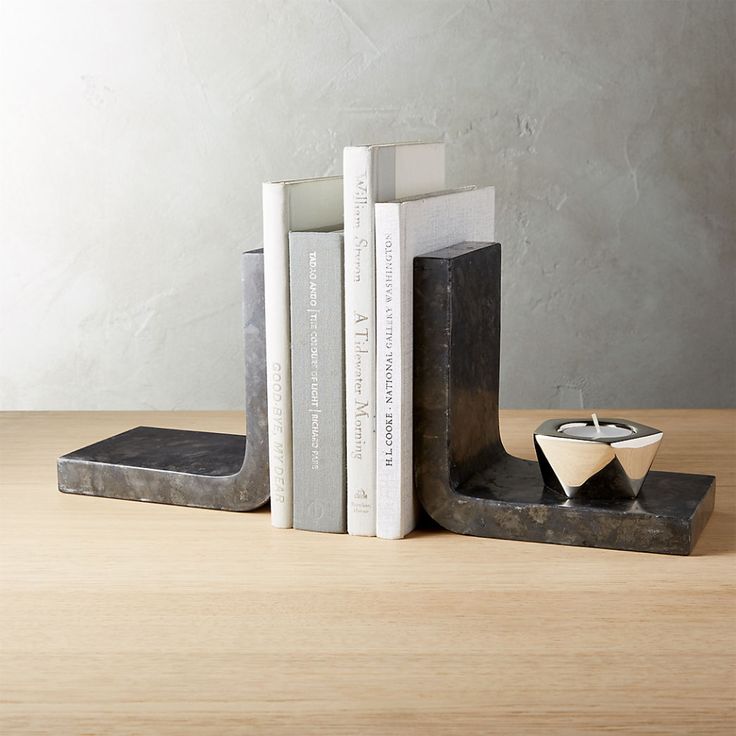 a bookend with two books and a candle holder on top of it, sitting on a table