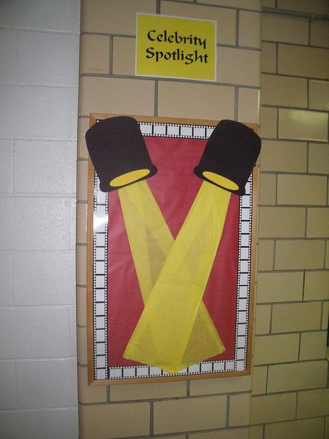 a bulletin board with two hats and suspenders on it's sides, in front of a brick wall