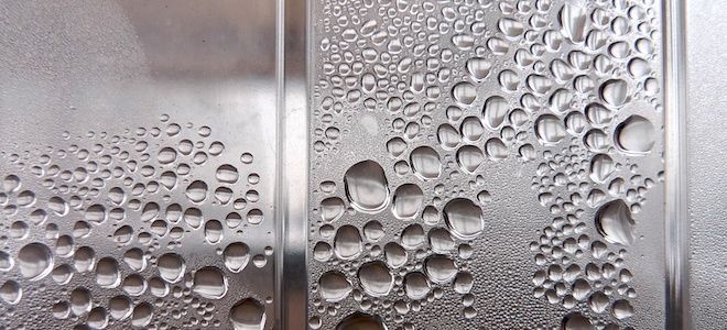 water drops on the glass door of a public restroom, as seen from below in close up