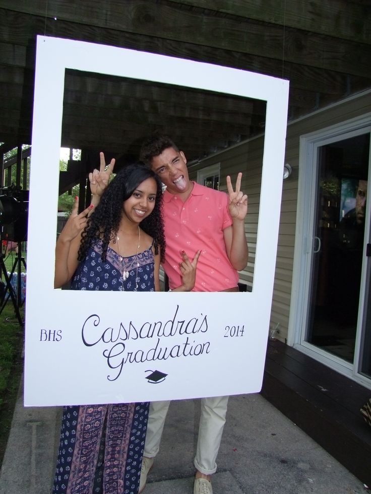 two people standing in front of a sign giving the peace sign