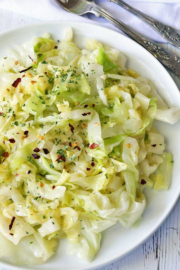 a white bowl filled with coleslaw and garnished with seasoning on top