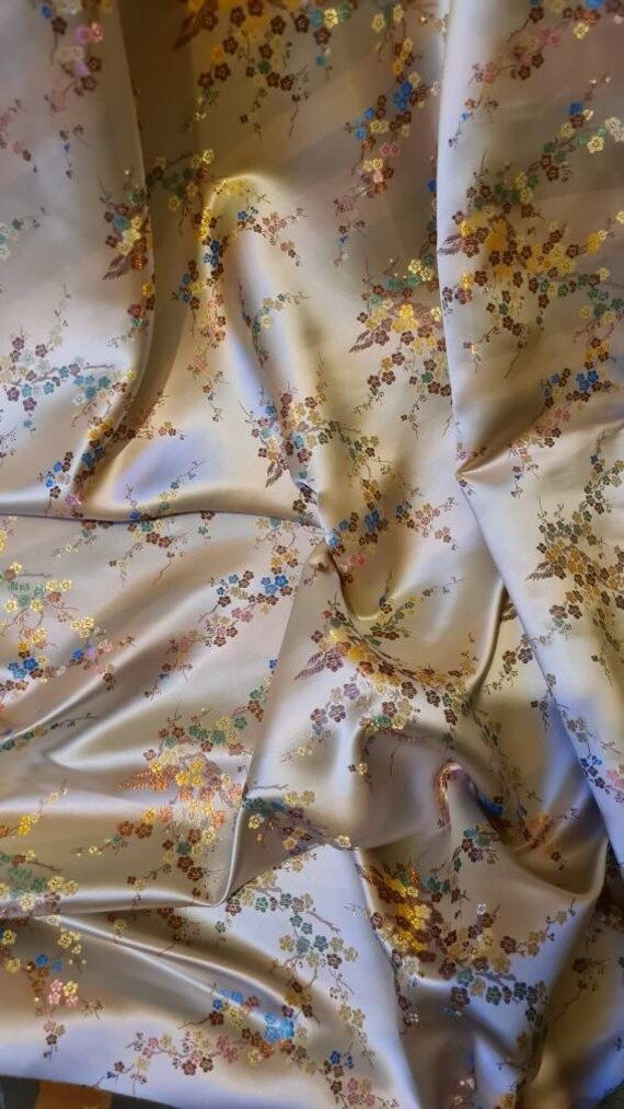 the fabric is covered with flowers and has been folded up to show it's pattern