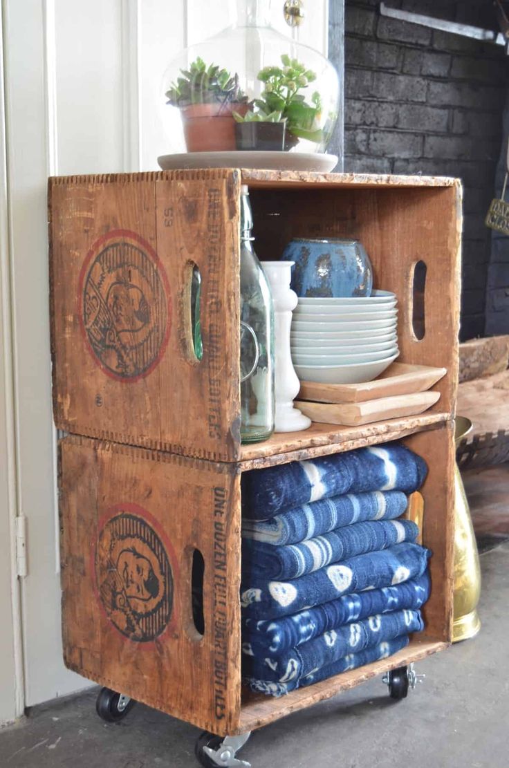 an old wooden crate is stacked with blue dishes and plates on it's wheels