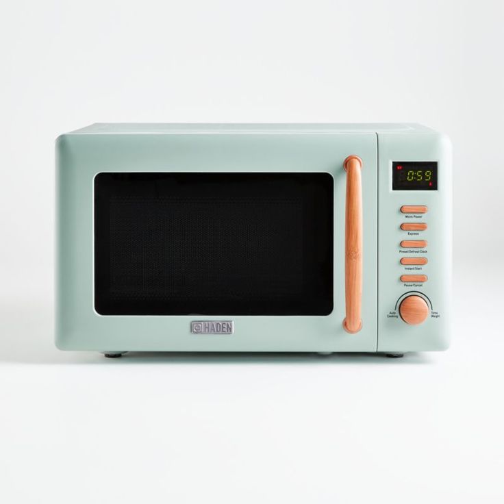 a blue microwave oven sitting on top of a white counter next to an orange timer