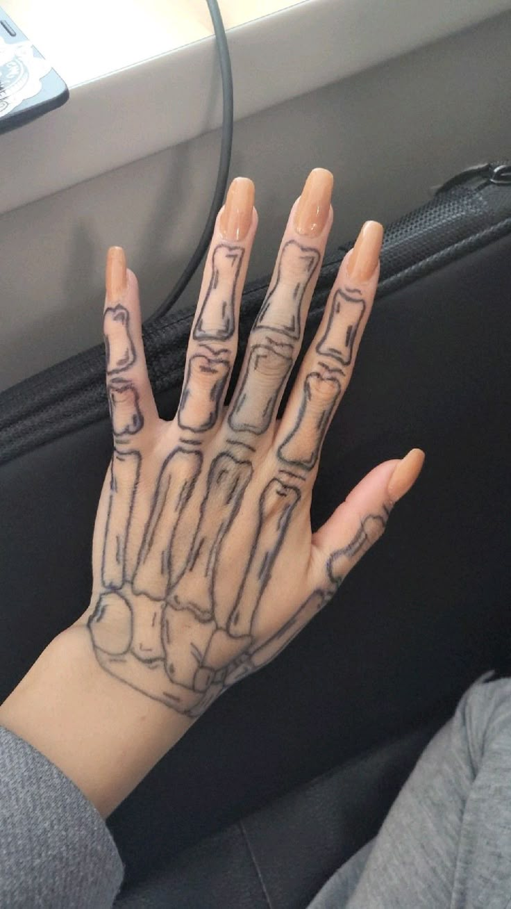 a person's hand with tattoos on it