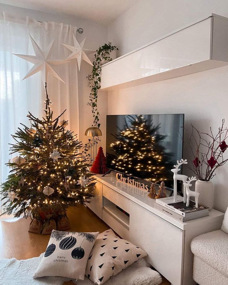 a living room with two christmas trees in the corner