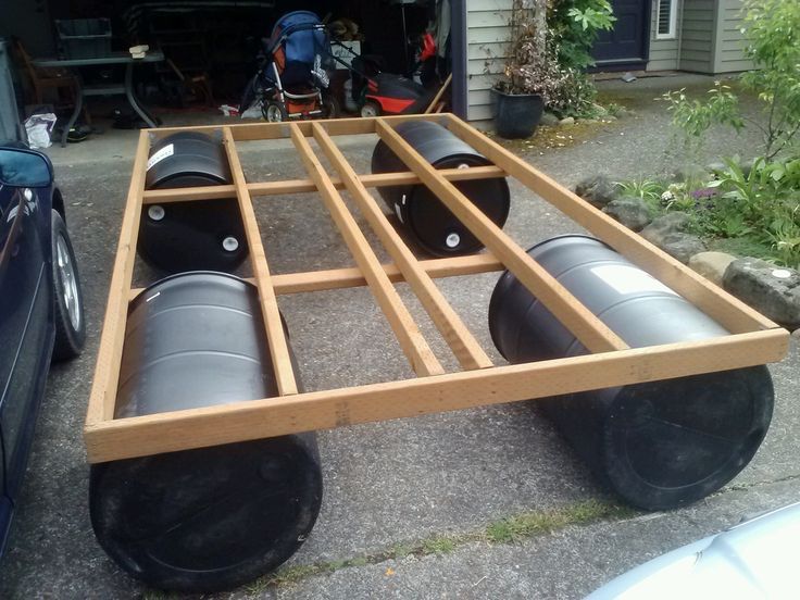 a car is parked in front of a garage with two large black barrels on it