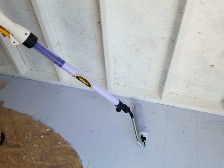 a purple and white umbrella laying on the ground next to a door with holes in it