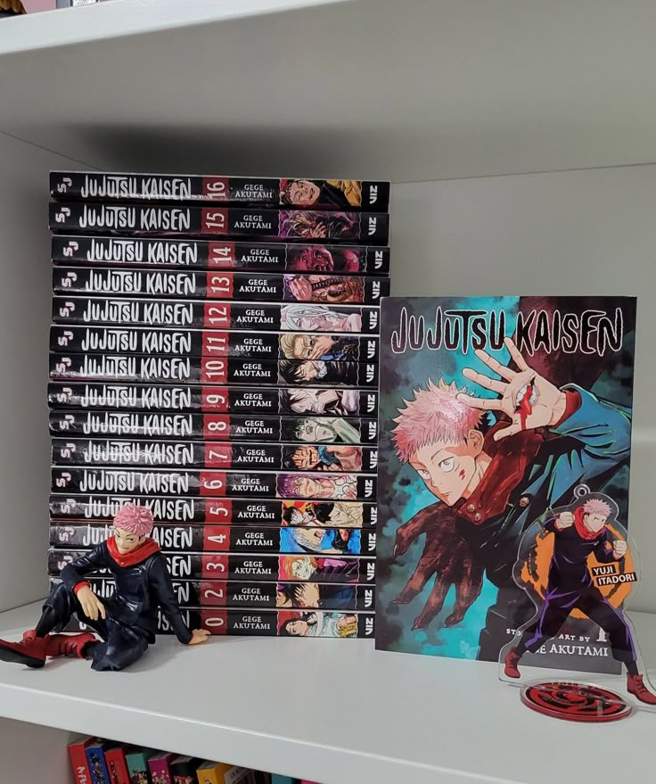 some anime figurines are sitting on a book shelf in front of a bunch of books