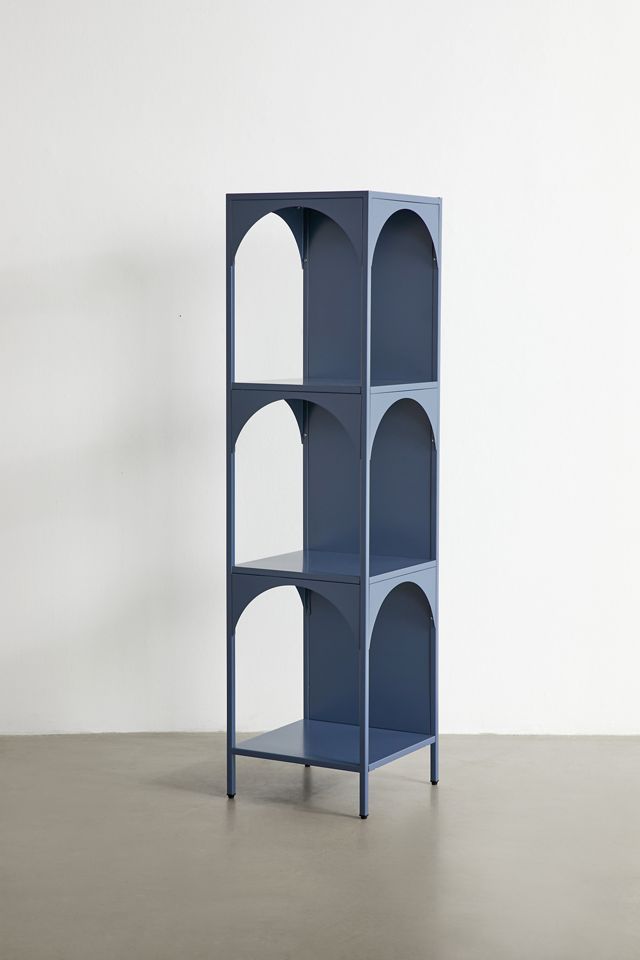 a tall blue shelf sitting on top of a cement floor next to a white wall