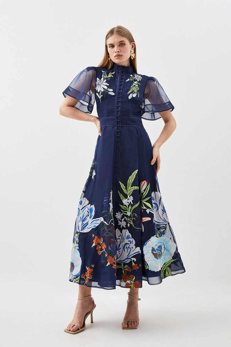 Ornate And Original, This Midi Dress Is Defined By Intricate Embroidery To The High-Neck Bodice, Offset By Semi-Sheer Long Sleeves And Tonal Buttons. Landing At A Delicately-Gathered A-Line Skirt, This Wedding-Ready Piece Calls For Tonal Stilettos And An Artful Floral Headband.High Necktonal Buttonsfloral Embroiderymidi Length Botanical Embroidery, Botanical Motifs, Wedding Outfit Ideas, Dark Dress, Wedding Guest Attire, Mother Of The Groom Dresses, Guest Attire, Wedding Attire Guest, Angel Sleeve