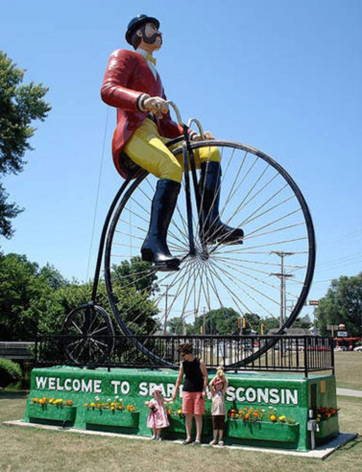 a statue of a man riding a giant bicycle