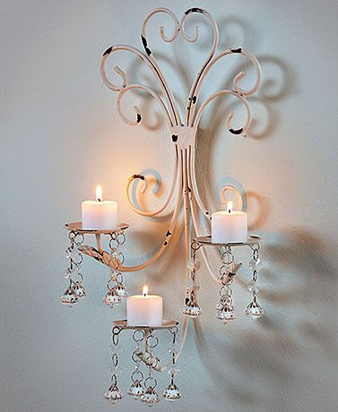 a wall mounted candle holder with three candles