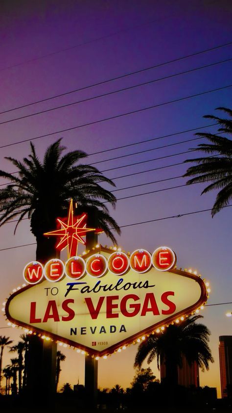 the welcome to fabulous las vegas sign lit up at night with palm trees in the background