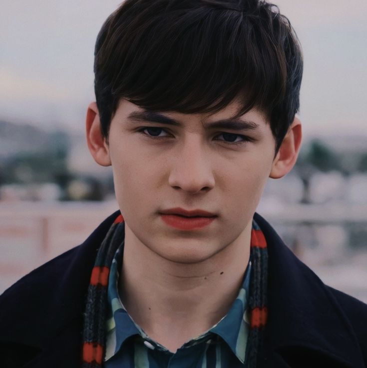 a young man is wearing a scarf around his neck