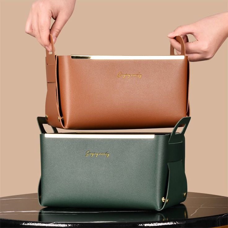 two women's hands holding purses stacked on top of each other in different colors