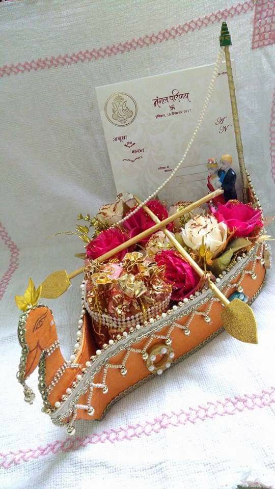 an elaborately decorated boat is sitting on a white tablecloth with pink and gold decorations