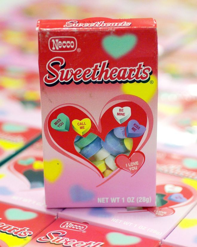 a box of sweethearts candy sitting on top of a pile of other candies