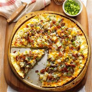 a pizza sitting on top of a wooden cutting board next to a bowl of peas