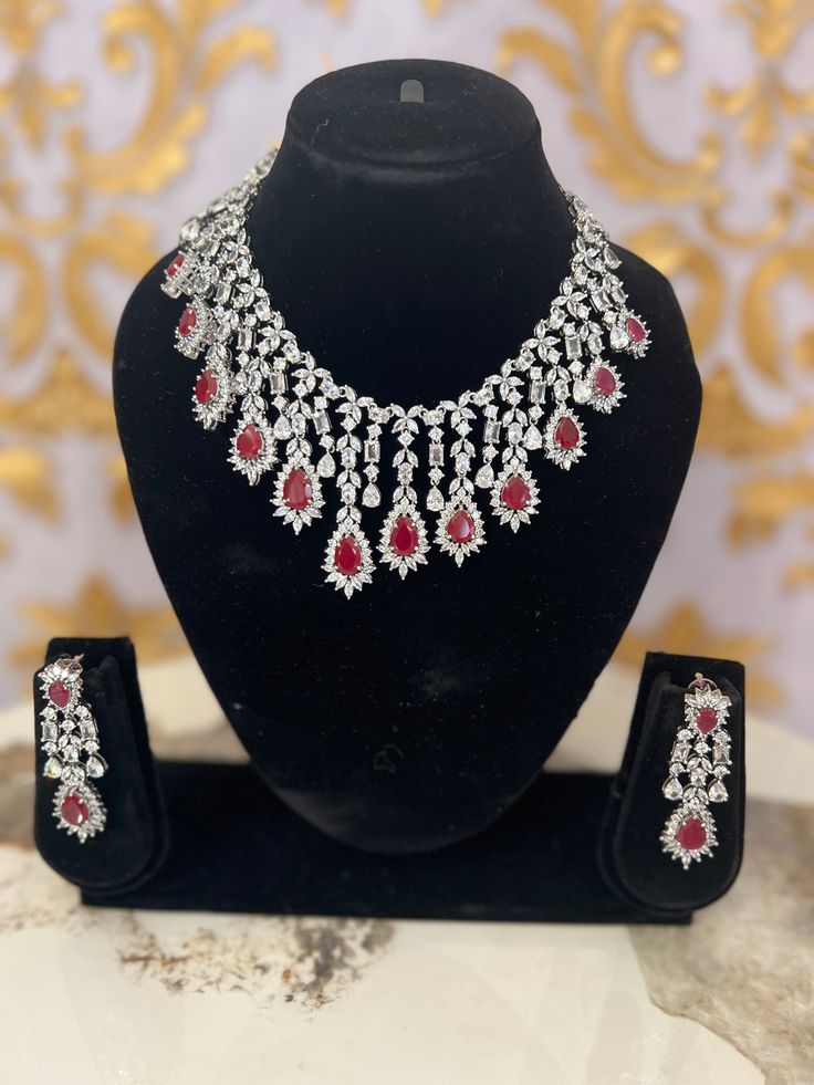 Experience the luxurious magnificence of our exquisite necklace set adorned with pearls, kundan, and gemstones. Elevate your look with the included pair of earrings. • The necklace's closure can be modified using a dori. • The earrings have a push back closure for a secure fit. Elegant Ruby Jewelry Sets For Reception, Luxury Stone Work Jewelry Sets For Formal Occasions, Elegant Ruby Bridal Necklace With Stone Work, Formal Bridal Necklace With Diamond And Tilla, Formal Bridal Necklace With Tilla And Diamonds, Formal Bridal Diamond Necklace With Tilla, Luxury Heavy Kundan Necklace For Formal Occasions, Elegant Kundan Necklace With Ruby For Reception, Elegant Ruby Bridal Necklace For Reception