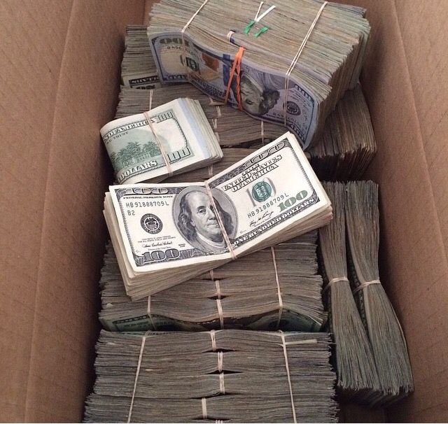 a box filled with stacks of dollar bills and bundles of money sitting on top of each other