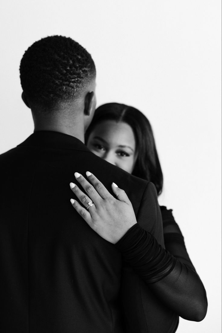 a black and white photo of a couple embracing