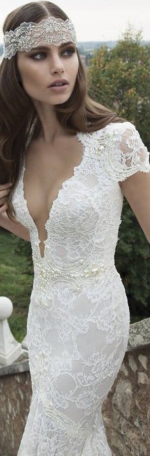 a woman in a wedding dress posing for the camera with her hands on her hips