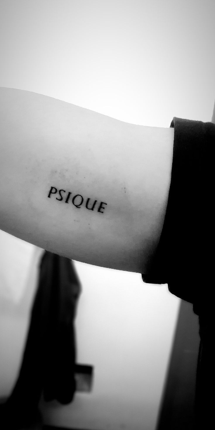 a black and white photo of a person's arm with a tattoo on it