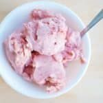 a white bowl filled with ice cream on top of a wooden table