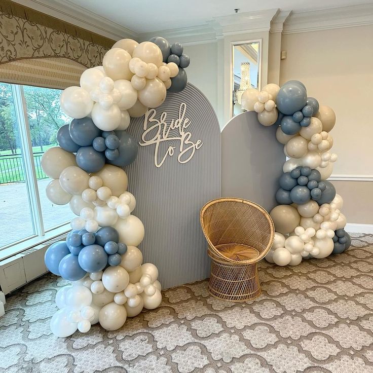 an arch made out of balloons with the words bride and groom on it in front of a window