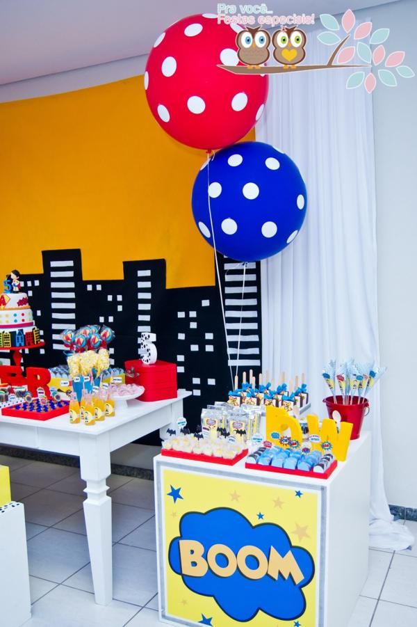 a table with balloons and cake on it in front of a room filled with other decorations