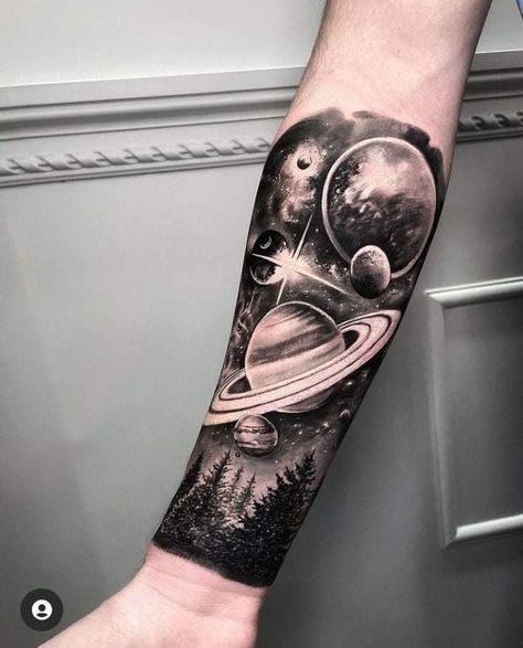 a man's arm with an image of planets and trees on it, in black ink