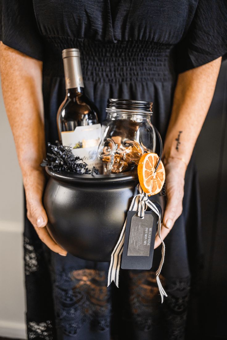 a woman is holding a caulder full of liquor and other things in it