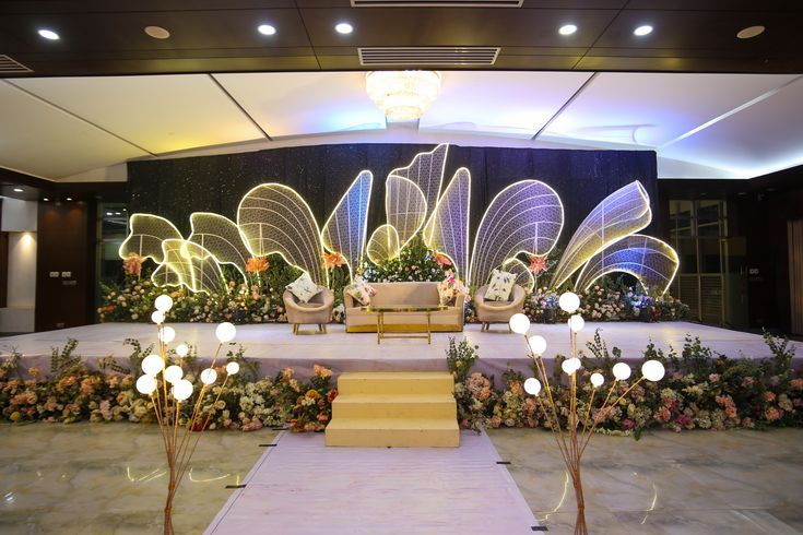 a decorated stage with chairs and flowers on it