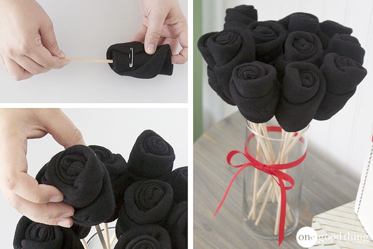 there is a vase with black roses in it and the flowers are tied to sticks