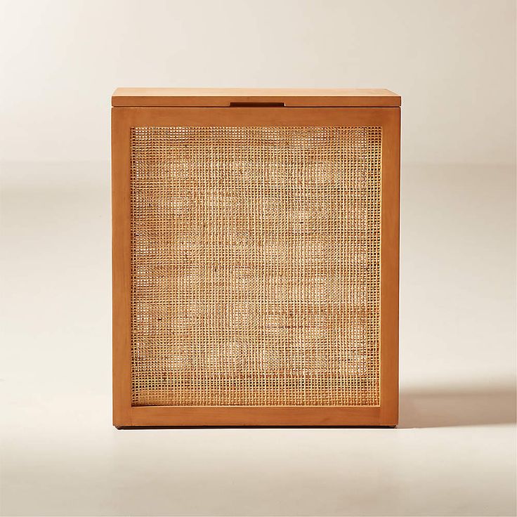 an empty wooden box with woven fabric on the front and sides, against a white background