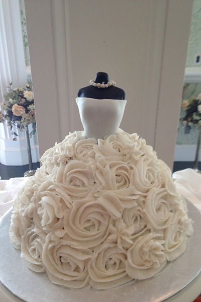 a wedding cake with white frosting roses on top