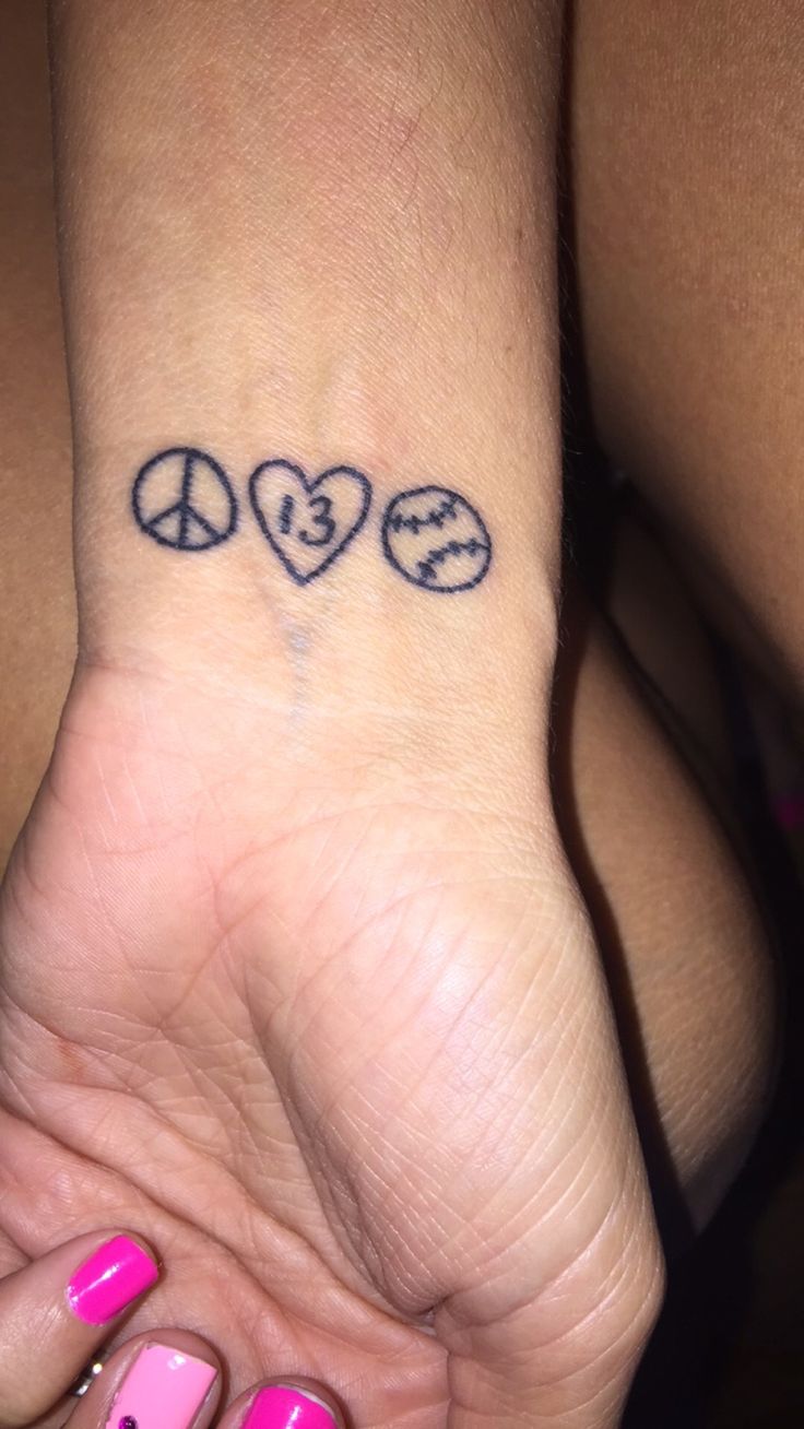 a woman's hand with a peace sign and hearts tattoo on it