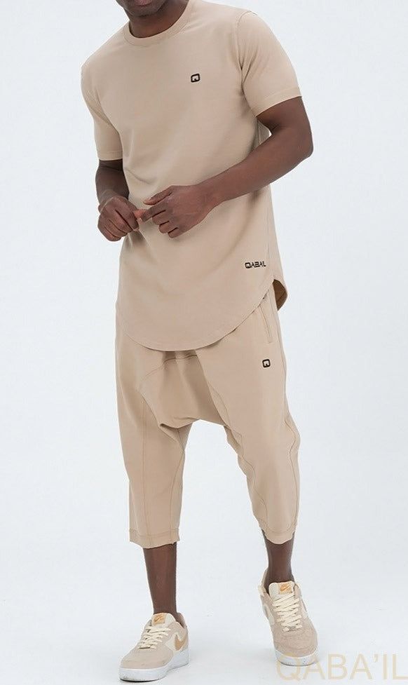 QL Relaxed Fit Nautik Set in Beige Description:Enjoy the warmth of summer with a fresh new look! This T-shirt and shorts set offers comfort, functionality and style. Featuring a shirt with a round neck and a stylish round hem and a three-quarter shorts that lets you enjoy the sun while keeping covered. This holiday wardrobe is all you need to feel at your best this season. Modern Islamic clothing for men Very high-quality fabric from top brands Short sleeved T-shirt with a small logo on the left Summer Cotton Sets With Built-in Shorts, Beige Leisure Shorts For Summer, Beige Cotton Short Sets, Beige Stretch Casual Shorts, Neutral Cotton Shorts For Summer, Casual Khaki Cotton Sets, Sporty Beige Tops For Summer, Summer Stretch Crew Neck Sets, Summer Stretch Short Sleeve Sets