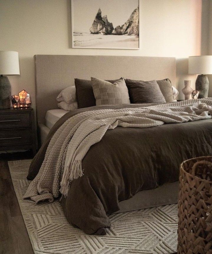 a bedroom with a large bed covered in blankets and pillows