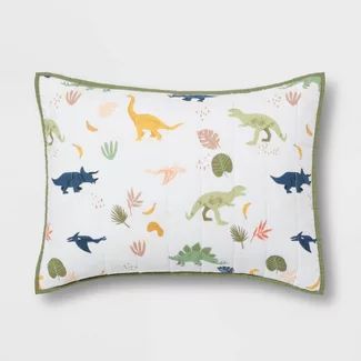 a white pillow with dinosaurs and plants on it