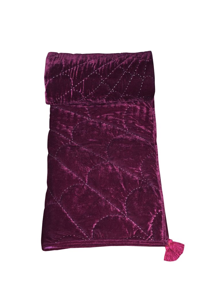 a purple velvet bag with tassels on it