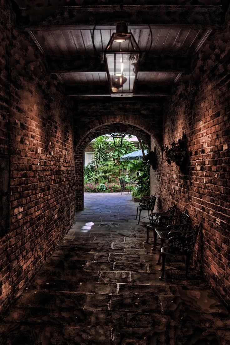 an old brick tunnel with chairs and lights