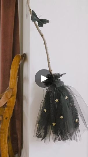 a wooden chair sitting next to a tree branch with two birds hanging from it's back