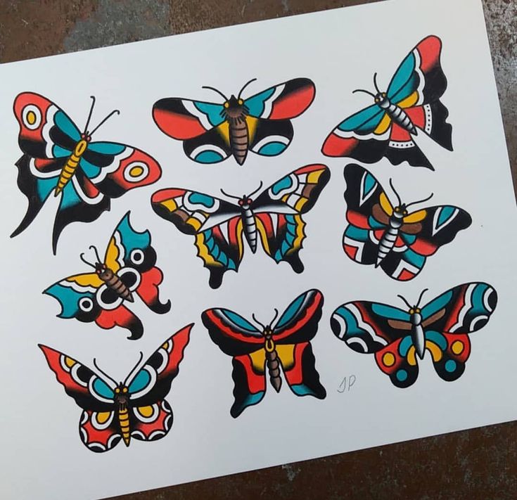 a bunch of butterflies that are on top of a piece of paper with different colors